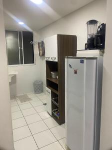 a kitchen with a refrigerator in a room at Apto 2Q com Area de Lazer e Piscina in São Gonçalo do Amarante