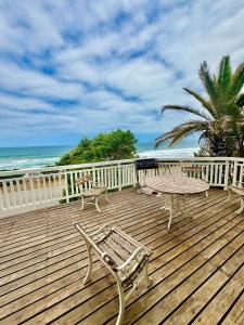 a wooden deck with a table and chairs on the beach at Skye Beach Villa in Tergniet