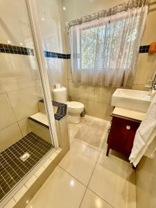 a bathroom with a shower and a sink and a toilet at Skye Beach Villa in Tergniet +66 photos