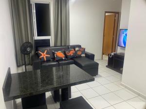 a living room with a couch and a table at Apto 2Q com Area de Lazer e Piscina in São Gonçalo do Amarante