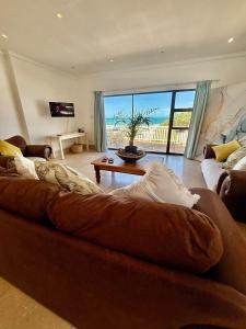 a large couch in a living room with a view of the ocean at Skye Beach Villa in Tergniet