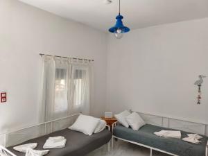 two beds sitting in a room with a window at white and blue,finikas syros in Víssa