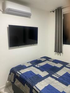 a bedroom with a bed and a flat screen tv at Apto 2Q com Area de Lazer e Piscina in São Gonçalo do Amarante +19 photos
