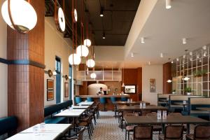 a restaurant with tables and chairs and a bar at Alt Hotel Ottawa Airport in Ottawa
