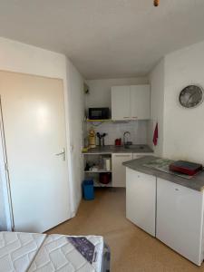 a small kitchen with white cabinets and a counter top at Appartement Port Leucate in Leucate +12 photos
