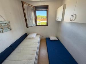 a small room with two beds and a window at Appartement Port Leucate in Leucate