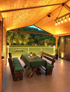 a wooden patio with a table and two benches at Stan na dan Bumbar in Kostajnica