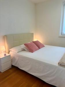 a bedroom with a white bed with two pillows on it at Villa Lena in Camaiore