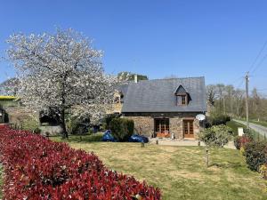 a house with a yard with flowers in front of it at Maison paisible Normandie in Saint-Aubin-de-Terregatte