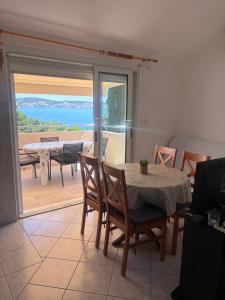 a dining room with a table and a view of the ocean at Apartmani Maleš in Rogoznica