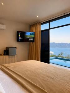 a bedroom with a large bed and a large window at Hotel y Restaurante Buganvilias in Las Aradas