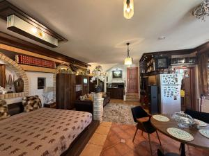 a bedroom with a bed and a table and a kitchen at Villa Éden in Siófok