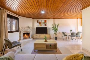 a living room with a tv and a fireplace at All Saints Retreat in Koilani