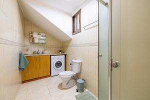 a bathroom with a toilet and a washing machine at All Saints Retreat in Koilani +7 photos