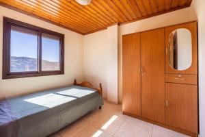 a bedroom with a bed and a large window at All Saints Retreat in Koilani