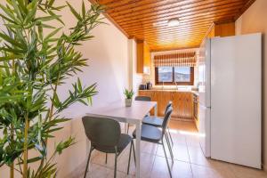 a kitchen with a table and chairs and a refrigerator at All Saints Retreat in Koilani