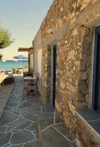 a stone house with a stone wall and a patio at Lodge Narlis in Platis Gialos