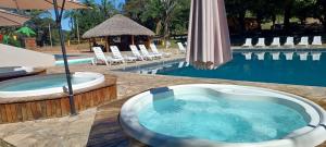 a jacuzzi tub next to a swimming pool at Complexo Turístico Canaã in Nobres