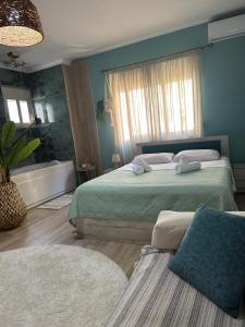 a blue bedroom with two beds and a window at Gjonis house in Sarandë