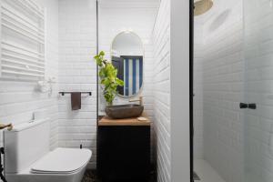 a bathroom with a sink and a toilet and a mirror at Ático La Mallera in Luanco +31 photos