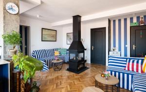 a living room with blue and white striped couches and a fireplace at Ático La Mallera in Luanco