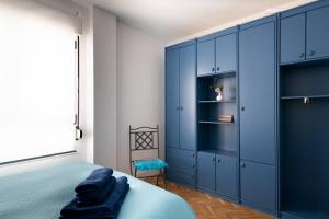 a bedroom with blue cabinets and a bed at Ático La Mallera in Luanco