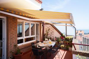 a patio with a table and chairs on a balcony at Ático La Mallera in Luanco