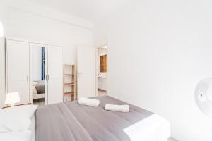 a white bedroom with a bed with two towels at Meilleur emplacement de Nice Charming Flat #3 in La Celle-sous-Gouzon +4 photos