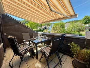 a patio with a table and chairs on a balcony at Ferienwohnung Kölbel Familienurlaub in der Natur in Schmallenberg