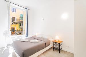 a white bedroom with a bed and a window at Meilleur emplacement de Nice Charming Flat #3 in La Celle-sous-Gouzon