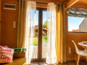 a room with a window with curtains and a table at Domki Nad Morzem Sobiescy in Stegna