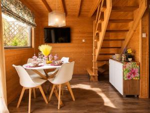 a dining room with a table and white chairs at Domki Nad Morzem Sobiescy in Stegna