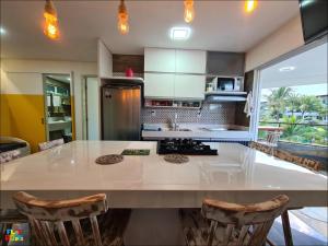 a kitchen with a large white island in a room at Best location of the development, ground floor seafront in Porto De Galinhas