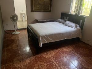 a bedroom with a bed and a fan in it at C24 guesthouse in Cap-Haïtien