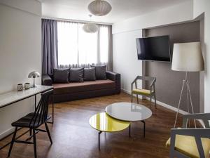 a living room with a couch and a table at Mercure Rosario in Rosario