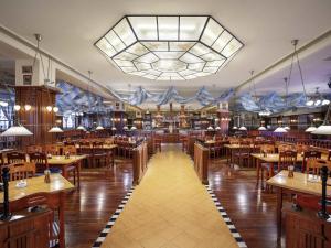 a large dining room with tables and a large chandelier at Swissôtel Shenyang in Shenyang