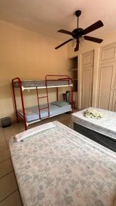 a room with two bunk beds and a ceiling fan at Hostal Sam in Managua +4 photos