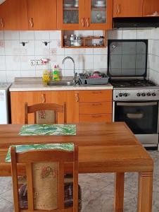 a kitchen with a table and a sink and a stove at Apartman Mare in Kaštela