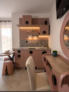 a kitchen with a counter and a table with chairs at Olea Luxury Suites in Asprovalta