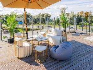 a patio with a couch and chairs and an umbrella at Mercure Tallinn in Tallinn