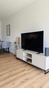 a living room with a flat screen tv on a white entertainment center at Nord Loft in Langeoog