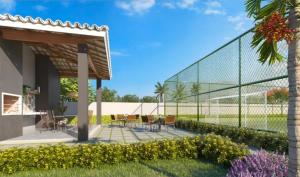 a patio with tables and chairs and a fence at Apartamento completo no Bérgamo in Feira de Santana