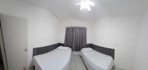 a room with two beds and a chandelier at Apartamento completo no Bérgamo in Feira de Santana +7 photos