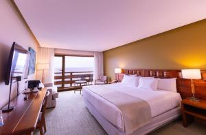 a hotel room with a large bed and a balcony at Wyndham Puerto Varas Pettra in Puerto Varas +37 photos