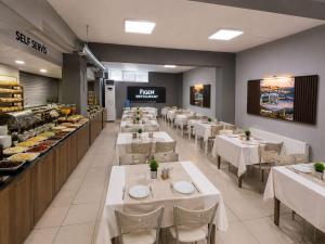 ein Restaurant mit weißen Tischen und Stühlen und eine Bäckerei in der Unterkunft Figen Suite Hotel 2 in Canakkale + 28 Fotos