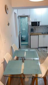 a living room with two tables and a kitchen at Kostaki spila apartment in Himare +12 photos