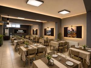 ein Restaurant mit Tischen und Stühlen in einem Raum in der Unterkunft Figen Suite Hotel 2 in Canakkale