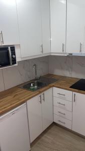 a kitchen with white cabinets and a sink at Kostaki spila apartment in Himare