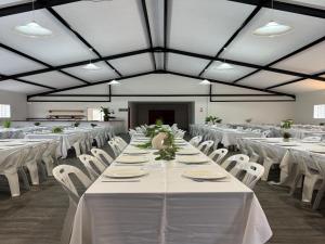 a large banquet hall with white tables and white chairs at St Helena Bay Hotel in St. Helena Bay