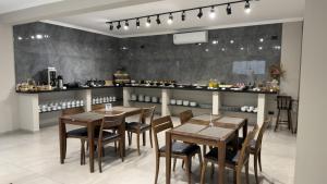 a restaurant with wooden tables and chairs and a counter at Asa Hotel in Piracicaba